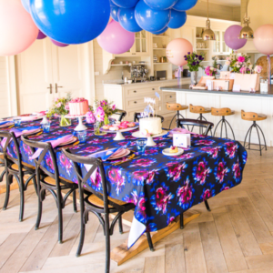 Image of a dining table setting with a blue floral printed tablecloth